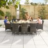 Amelia 8 Seat Rattan Dining Set - 2m x 1m Rectangular Gas Firepit Table distant shot of the set with family members using it