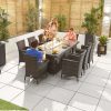 Amelia 8 Seat Rattan Dining Set - 2m x 1m Rectangular Gas Firepit Table slightly elevated shot of the set with family members using it