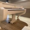 Grand Piano Gattopardo in a room showing the front.